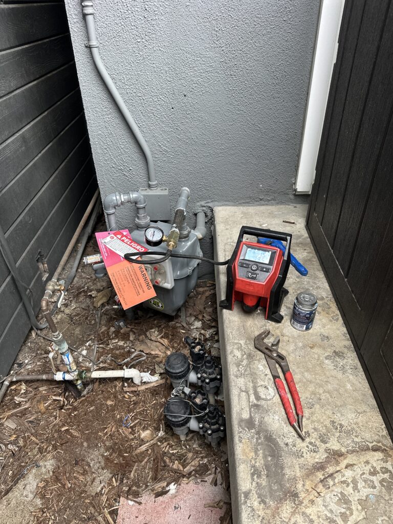 Technician performing natural gas leak detection on residential gas line using professional testing equipment