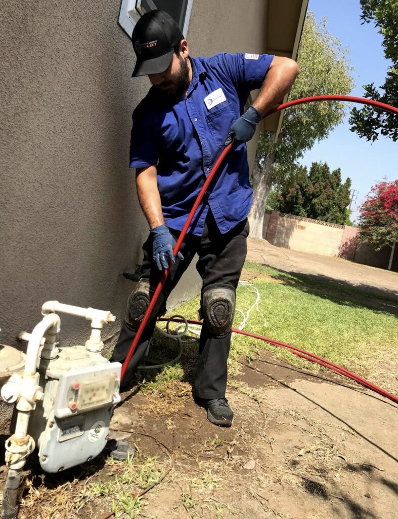 Hydro jetting equipment cleaning a sewer line using high pressure water to remove grease, roots, and buildup from inside the pipe