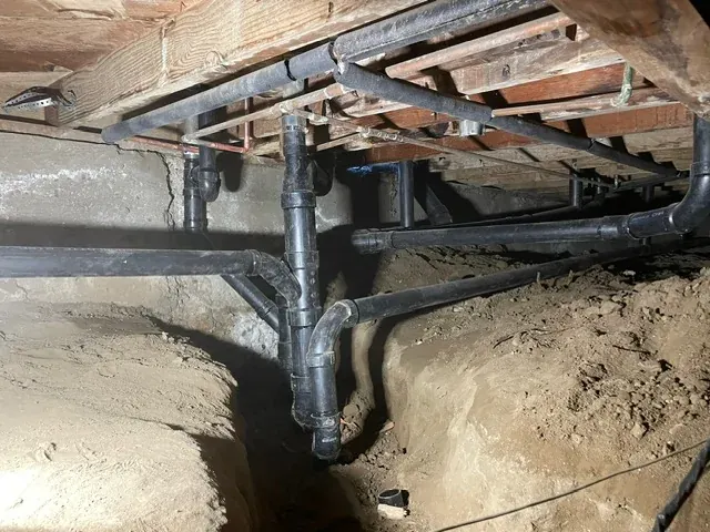 Drain pipes and fittings installed below a raised foundation